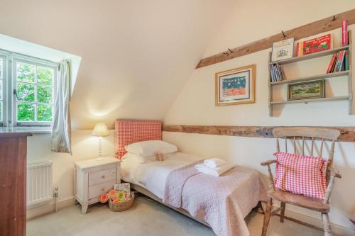 EastdeanBeachy Barn的卧室配有床、椅子和窗户。