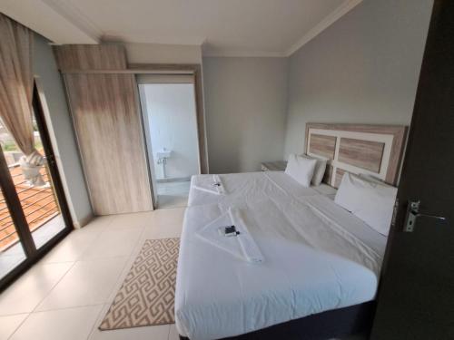 马塞卢Jate Guest House的一间卧室配有一张带白色床单的大床