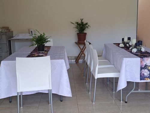 马塞卢Jate Guest House的用餐室配有2张桌子和白色椅子