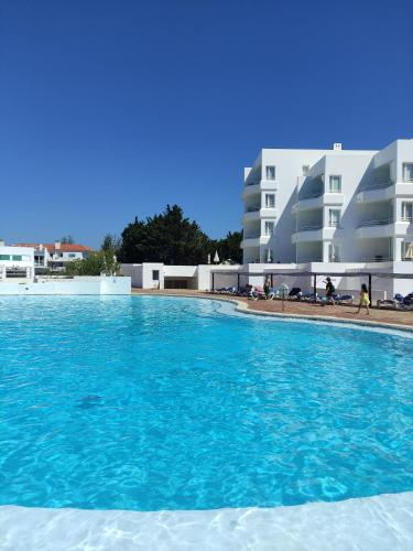 阿尔沃尔普赖尼亚俱乐部酒店的一座蓝色海水游泳池,位于部分建筑前