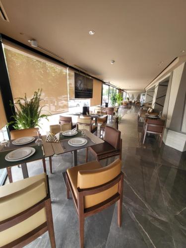 丹吉尔Hotel Appartement Tanger的餐厅设有桌椅和大窗户。