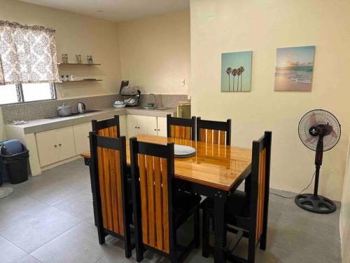 圣费尔南多Cozy Apartment near beach的厨房配有木桌、椅子和风扇