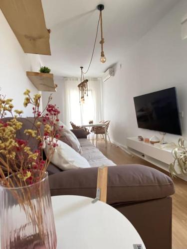 比利亚努埃瓦-赫尔特鲁Apartamento en Vilanova, Ático的客厅配有沙发和鲜花桌