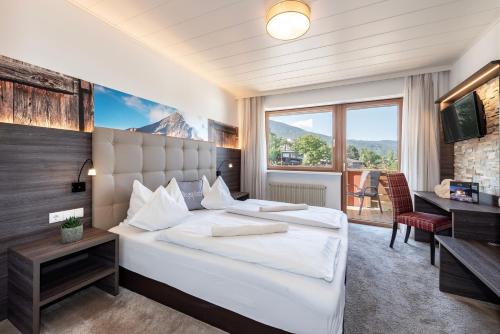 布列瑟农蒂罗尔酒店的一间卧室设有一张大床和一个大窗户