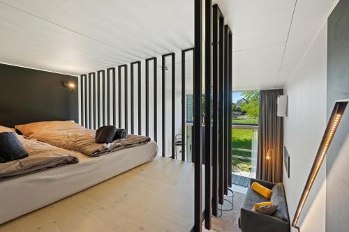 劳特阿赫KODA LOFT EXTENDED - Urlaub im Tiny House Bodensee的一间卧室设有一张床和一个大窗户