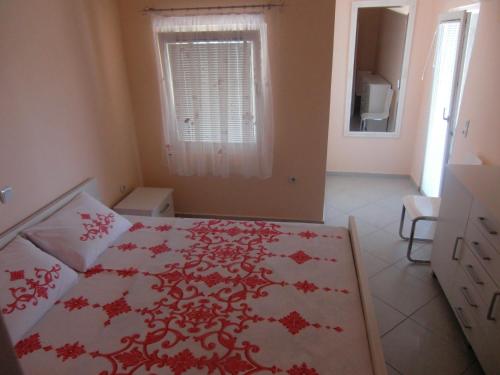 蒂瓦特Apartment Villa Dobrijevic -Seljanovo的一间卧室配有一张带红色和白色床罩的床。