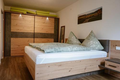 奥伊-米特尔贝格Ferienwohnung Bergzeit的一间卧室配有一张带木制床头板的床