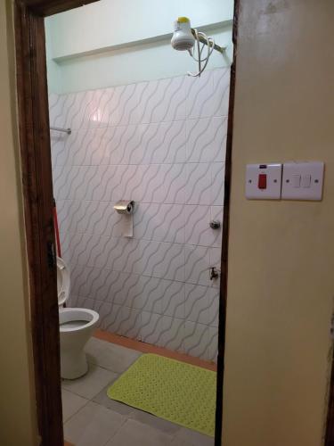 埃尔多雷特G&G Westindies Executive One Bedroom的带淋浴、卫生间和绿色地毯的浴室