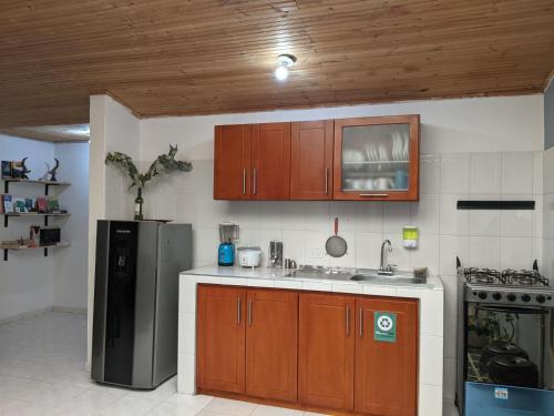 苏埃斯卡Casa GO的厨房配有木制橱柜和不锈钢冰箱。