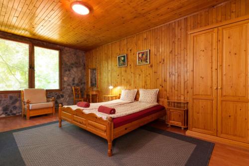EmenEco Hotel Imenieto的卧室配有一张床铺,位于带木墙的房间内