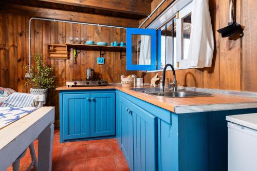 MajanichoCabin in front of idyllic majanicho beach的厨房配有蓝色橱柜和水槽