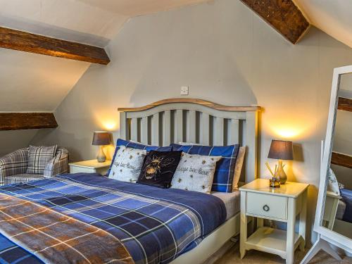 多尔顿因弗内斯Beeswax Cottage的一间卧室配有蓝色的床和2个床头柜