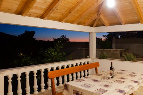 布拉托Panoramic Apartments Anić的门廊上的桌子和一瓶葡萄酒