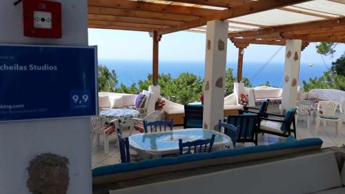 GialiskariKocheilas Studios的一个带桌椅的庭院和大海