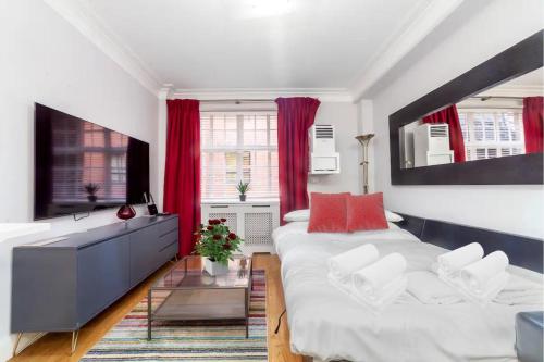 伦敦Modern Quiet 1 bed Flat -Mayfair的一间卧室配有大床和红色窗帘