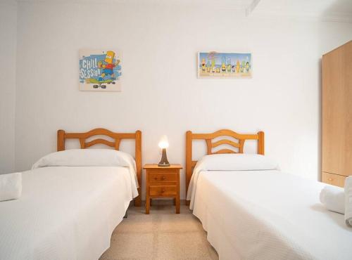 桑卢卡尔-德巴拉梅达SibsSanlucar Albero - Ideal Familias - Centro - Playa Piletas的客房设有两张床和一张带台灯的桌子。