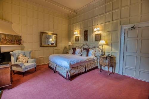 切斯特勒斯特里特拉姆利城堡酒店的一间卧室配有一张床和一把椅子