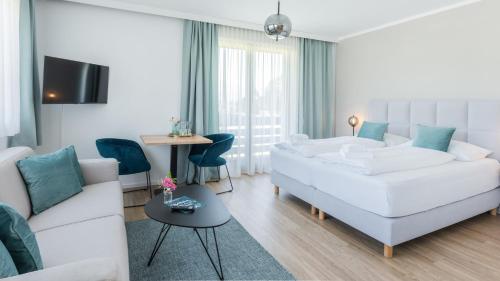 法克湖畔杜罗博拉赫Marienhof Apartments的客厅配有白色的沙发和桌子