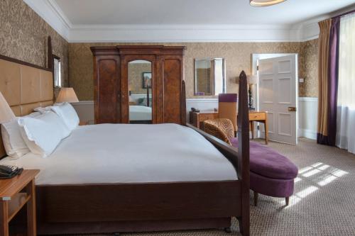 萨顿·斯科特尼Norton Park Hotel, Spa & Manor House - Winchester的一间卧室配有一张大床和一张书桌