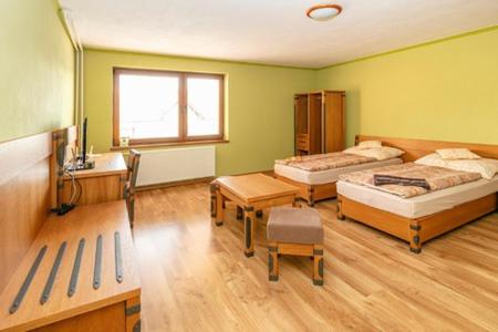 杜丁西ONYX Penzión的一间卧室设有两张床、一张桌子和一个窗口。