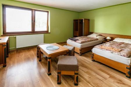 杜丁西ONYX Penzión的客房设有两张床、一张桌子和一张书桌。