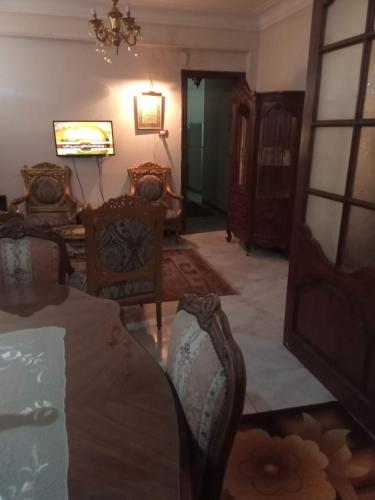 Kafr al IshārahGibran residence的客厅配有椅子、桌子和吊灯。