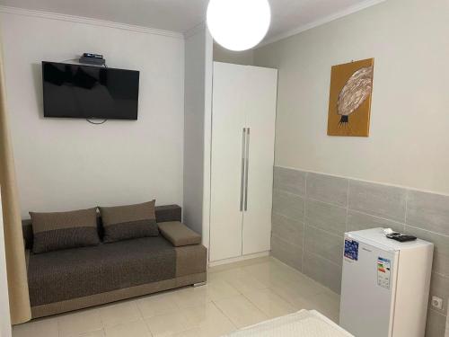 豪伊杜索博斯洛Adam Apartman的客厅配有沙发和墙上的电视