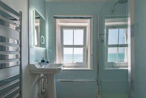 桑盖特Wave Cottage by Bloom Stays的一间带水槽、窗户和淋浴的浴室