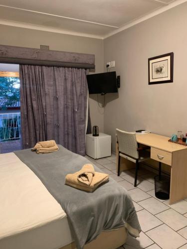 温特和克Hotel Pension Casa Africana的一间卧室配有一张床、一张书桌和一张书桌