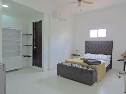 巴兰基亚Apartahotel Baq Suite 44的一间白色客房内的床铺卧室