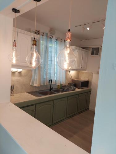 蓝海湾Blue Paradise的厨房配有水槽和一些灯