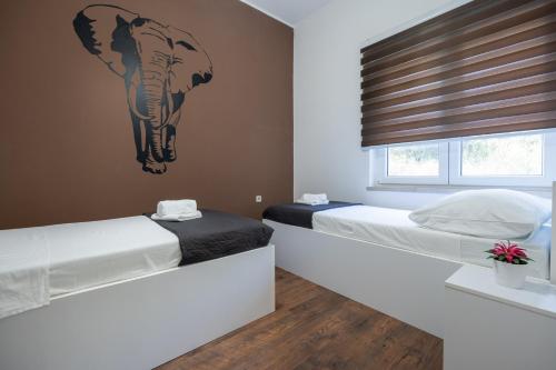 斯顿Ivano的卧室内的两张床,墙上挂着大象的照片