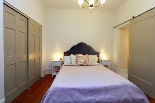 萨凡纳Queen Anne's Condo的一间卧室配有一张大床和紫色毯子