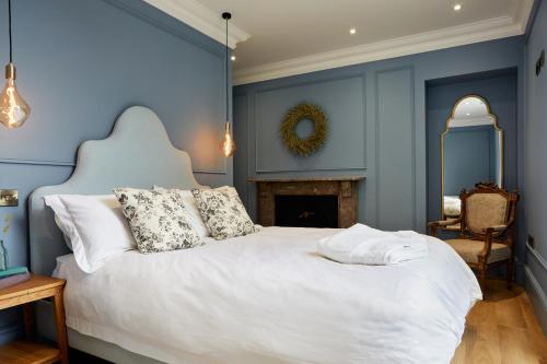约克Railway House York by Chateau Anna的一间卧室配有白色的床、蓝色的墙壁和壁炉