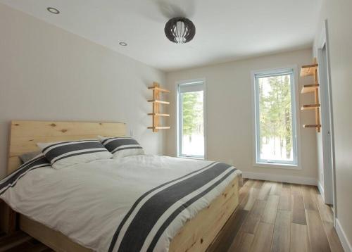 圣弗朗索瓦小河Le Vaillant du Massif的一间卧室设有一张大床和两个窗户。