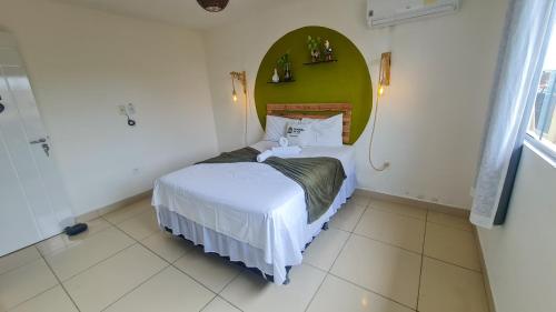 嘎林海斯港Cantinho da Gê Suítes的小卧室配有一张带绿色床头板的床