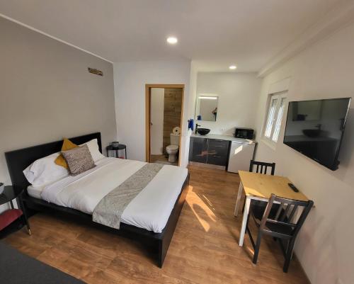 阿尔科巴萨Guesthouse of Alcobaça的一间卧室配有一张床、一张桌子和一台电视