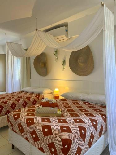 萨尔瓦多Casa de praia no Flamengo的一间卧室配有一张带天蓬的大床