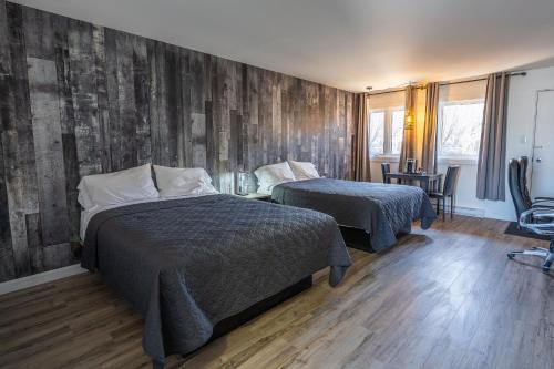拉马巴耶Le 2020 Charlevoix的一间卧室设有两张床和木墙