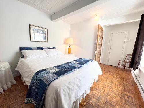 Saint-Férréol-les-Neiges蒙莫朗西山林小居的一间卧室配有一张带蓝白色毯子的床