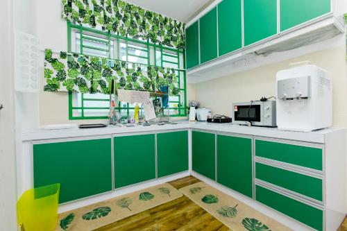 哥打丁宜Desaru 16Pax Family with Private Mini Pool & Jacuzzi的绿色白色厨房,配有绿色橱柜