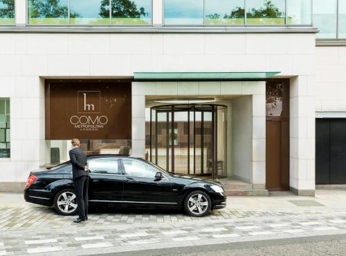 伦敦伦敦大都会COMO酒店的站在一座大楼前的一辆黑色汽车旁的人