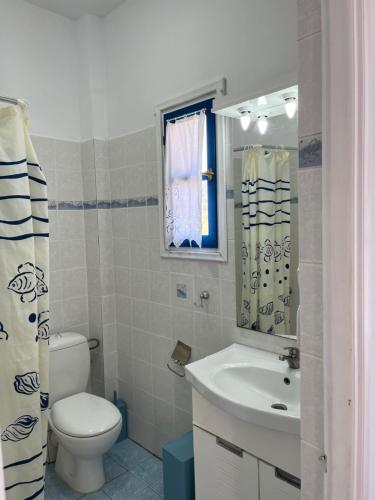 Platia AmmosΞΕΝΟΔΟΧΕΙΟ ΑΚΡΩΤΗΡΙ的一间带卫生间、水槽和镜子的浴室