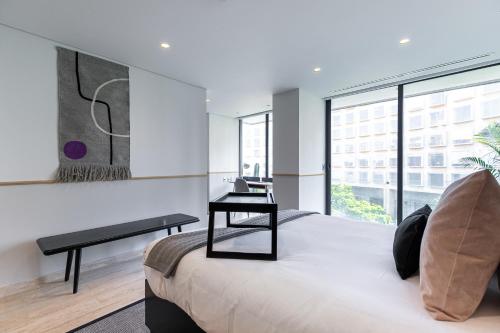 墨西哥城ULIV Antara的一间卧室配有一张带书桌的床和窗户。