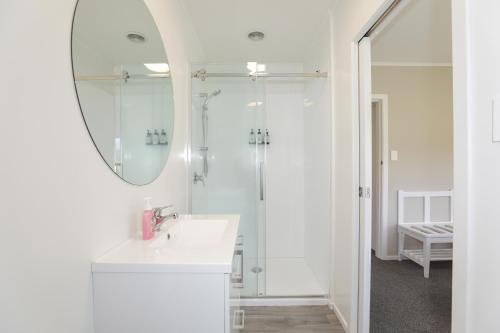 罗托鲁瓦The Greenkeeper's Cottage的白色的浴室设有水槽和镜子
