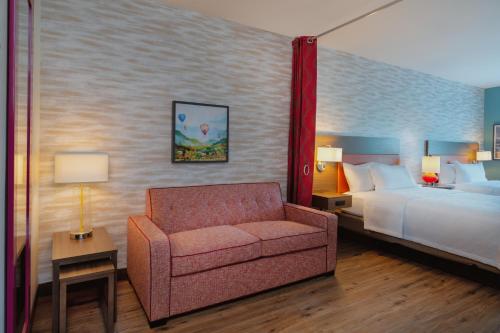 哈瓦苏湖城Home2 Suites By Hilton Lake Havasu City的一间卧室配有一张床、一张沙发和一把椅子