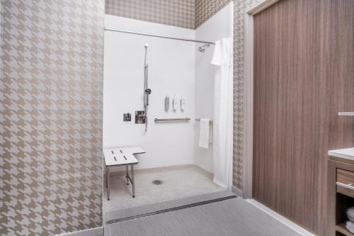 哈瓦苏湖城Home2 Suites By Hilton Lake Havasu City的带淋浴的浴室和长凳