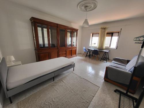 卡帕里卡Margem Sul rooms的一间卧室配有一张床、一张沙发和一张桌子
