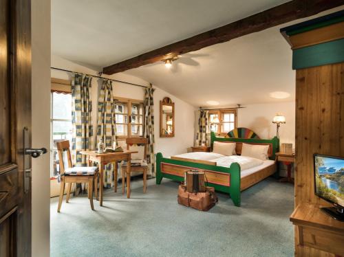巴德加斯坦MONDI Bellevue Alm Gastein的一间卧室配有一张床、一张桌子和一台电视