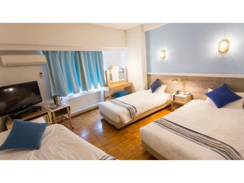 境港市Hotel AreaOne Sakaiminato Marina - Vacation STAY 09684v的酒店客房设有两张床和一台平面电视。